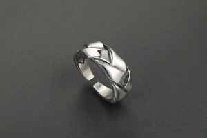 Macro shot of silver woven stainless steel adjustable ring with polished texture