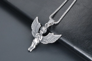 Detailed view of silver cherub angel pendant with intricate wings on metal box chain