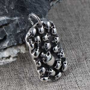 Macro shot of a gothic punk silver dog tag necklace with embossed 3D skulls design