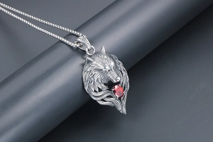 Detail view of titanium steel wolf head pendant with red zirconia stone on box chain