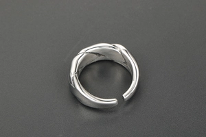 Macro detail of silver adjustable woven twist ring with intricate braided metal texture