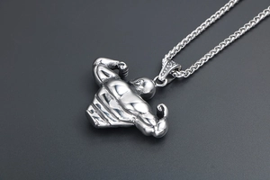 Macro shot of a silver muscle man pendant with detailed anatomy and durable steel chain