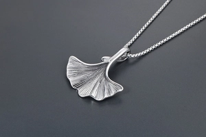 Macro del ciondolo a foglia di ginkgo argento con venature dettagliate su catena box