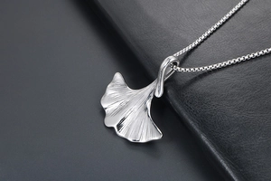 Dettaglio di un ciondolo a foglia di ginkgo argento con venature delicate e catenina