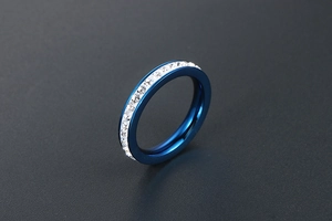 Dettaglio ravvicinato di un anello in acciaio al titanio blu con zirconi incastonati a canale
