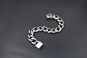 Macro view of silver titanium steel cuban chain bracelet with secure box clasp closure