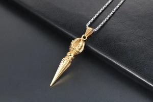 Detailed shot of two-tone gold vajra pestle pendant on a silver box chain necklace