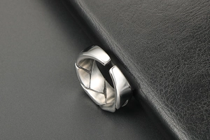 Macro detail of silver woven texture on adjustable stainless steel band for men