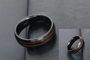 Gros plan détaillé d'une bague en acier titane noir poli avec incrustation de bois brun