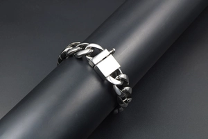 Macro shot of polished titanium steel cuban link bracelet with a square push-pull clasp