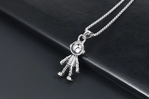 Détail du collier pendentif astronaute en argent poli sur un fond en cuir noir élégant