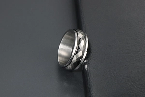 Macro view of men's silver hammered ring showing unique textured surface and metal polish