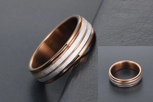 Detailed macro view of dual-tone titanium steel ring with rose gold and brushed silver finish