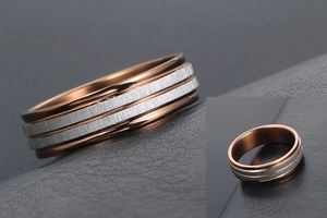 Close-up of two-tone titanium steel ring with rose gold edges and brushed silver inlay