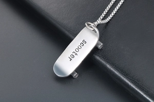 Nahaufnahme von silbernem Skateboard-Anhänger mit Scooter-Gravur an einer Box-Kette