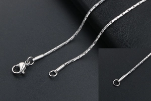 Close-up of a silver stainless steel chain necklace with a lobster clasp closure