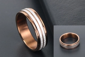 Detailed close-up of rose gold titanium ring with parallel brushed silver stripes