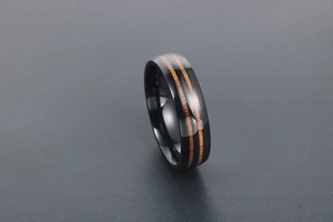 Gros plan sur une bague en titane noir poli avec double insert en grain de bois