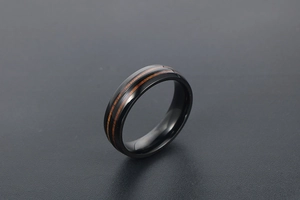 Détail de bague en titane noir avec deux incrustations parallèles en bois pour couple