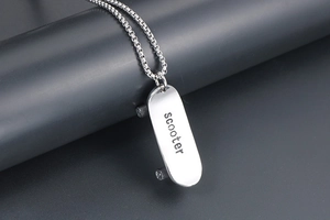 Detailansicht eines silbernen Roller-Anhängers mit Gravur und glänzender Metallkette