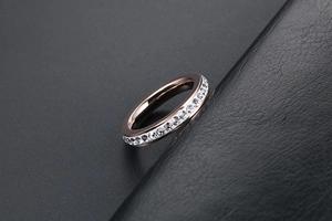 Dettaglio anello eternity in oro rosa con zirconi brillanti su pelle nera pregiata