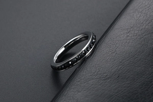 Dettaglio di un anello minimalista in argento con una fila di zirconi neri sfaccettati
