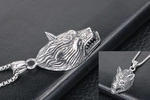 Macro shot of silver wolf head pendant showing vintage texture and box chain details