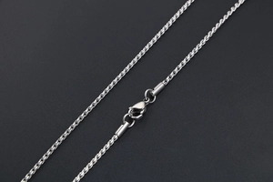 Macro shot of a silver titanium steel rope chain showing the lobster clasp detail