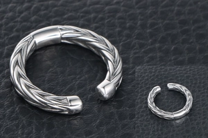 Macro shot of a silver titanium steel hinged hoop with twisted wheat ear texture