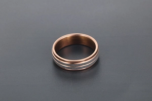 Macro shot of rose gold titanium ring with brushed silver-grey decorative dual parallel bands