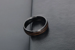 Vue macro d'une bague en titane noir avec deux incrustations parallèles en bois brun