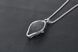 Macro shot of vintage wolf fang pendant in titanium steel with black texture inlay