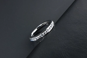 Dettaglio anello eternity in acciaio al titanio con pavé di zirconi su pelle nera di lusso