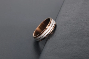 Macro shot of two-tone stainless steel ring featuring brushed silver and rose gold finish