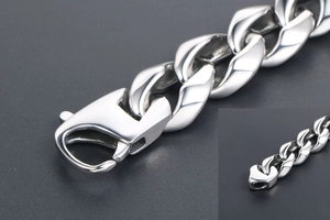 Gros plan sur le bracelet gourmette punk industriel avec détail de grand fermoir mousqueton