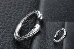 Macro view of silver wheat spike twisted cable titanium steel open ring on leather