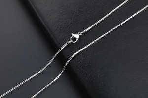 Detailed macro view of silver stainless steel chain necklace with lobster clasp closure