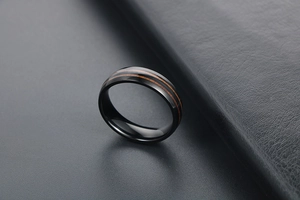 Vue détaillée d'une bague en acier titane noir avec double incrustation boisée