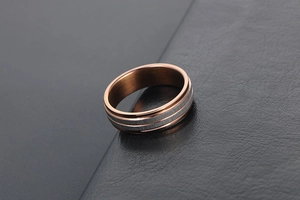 Macro shot of two-tone titanium steel ring with rose gold edges and brushed silver center