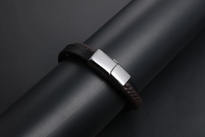 Détail d'un bracelet en cuir tressé multicouche avec un fermoir magnétique poli