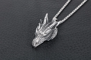 Détail du pendentif tête de dragon argenté texture vintage sur cuir noir élégant