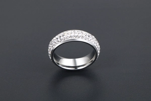 Détail macro d'une bague en acier titane argenté avec plusieurs rangées de cristaux pavés