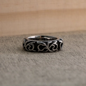 Detail of vintage titanium steel ring featuring intricate engraved floral vine patterns