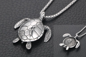 Macro detail of titanium steel sea turtle pendant with textured shell on black leather