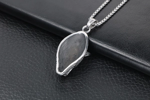 Detailed macro view of wolf-style stainless steel pendant with gray stone inlay