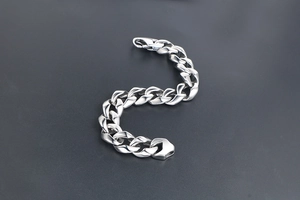 Détail d'un bracelet gourmette en acier inoxydable poli avec un fermoir en métal sûr