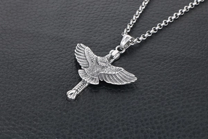 Détail macro du pendentif aigle avec textures de plumes sur une chaîne argentée