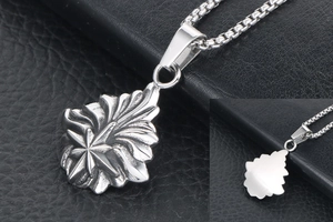 Détail du pendentif vintage argenté avec motifs en relief et chaîne de boîte