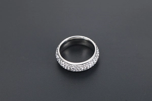 Gros plan sur une bague en argent ornée d'un pavage complet de cristaux blancs