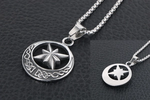 Macro view of vintage stainless steel crescent moon and star pendant on black leather